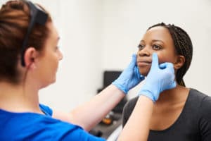 Shot of a beautiful young woman getting her face analyzed by a nurse at a beauty clinic