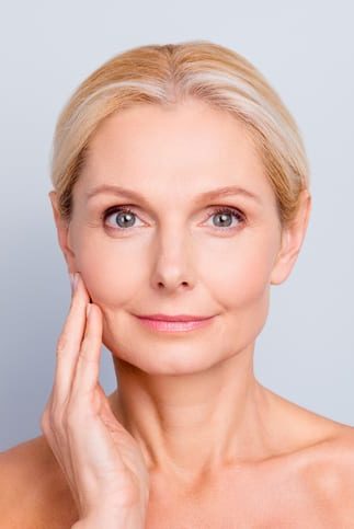 Portrait of pretty, attractive, charming, naked, nude woman touching her perfect skin, isolated on grey background, after peeling, lotion, mask, perfection, wellness, wellbeing, hydration concept