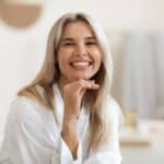 blonde woman in white silky bathrobe smiling