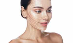 Beautiful dark-haired woman with lines illustrating facelift and neck lift treatment areas on her face and neck